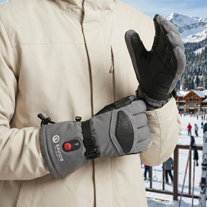 Ein Mann, der graue beheizbare Skihandschuhe trägt
