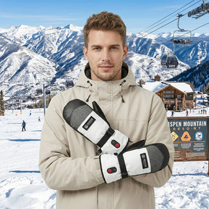 Ein junger Mann mit beheizbaren Fäustlingen von Savior Heat in einem Skigebiet
